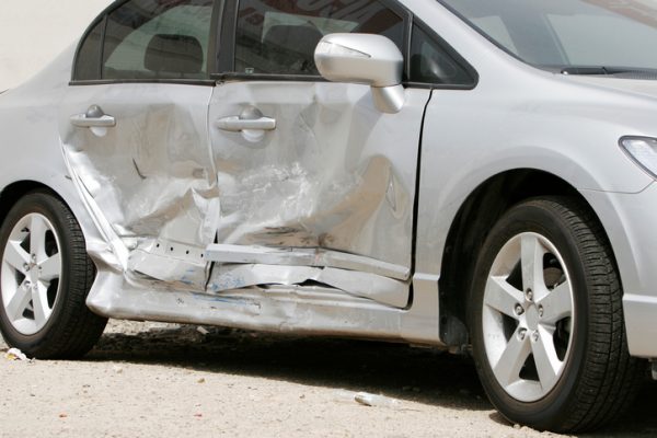 silver car with damage to the passenger side doors after accident