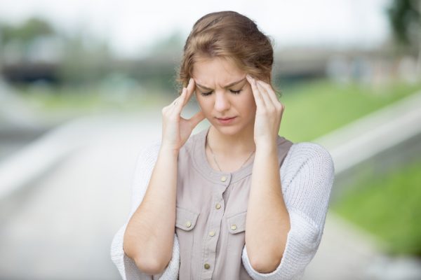 woman holds her temples after an accident