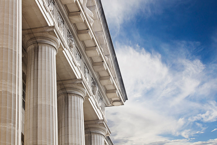 courthouse columns against cloudy blue sky