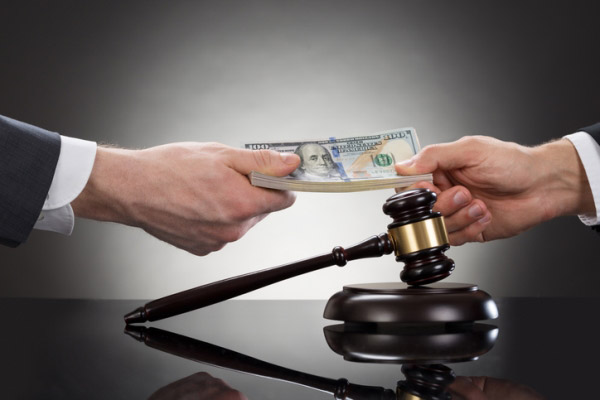 hands exchanging money next to a gavel