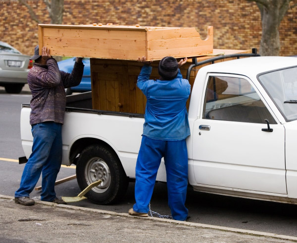 men loading furniture into the back of a pickup truck